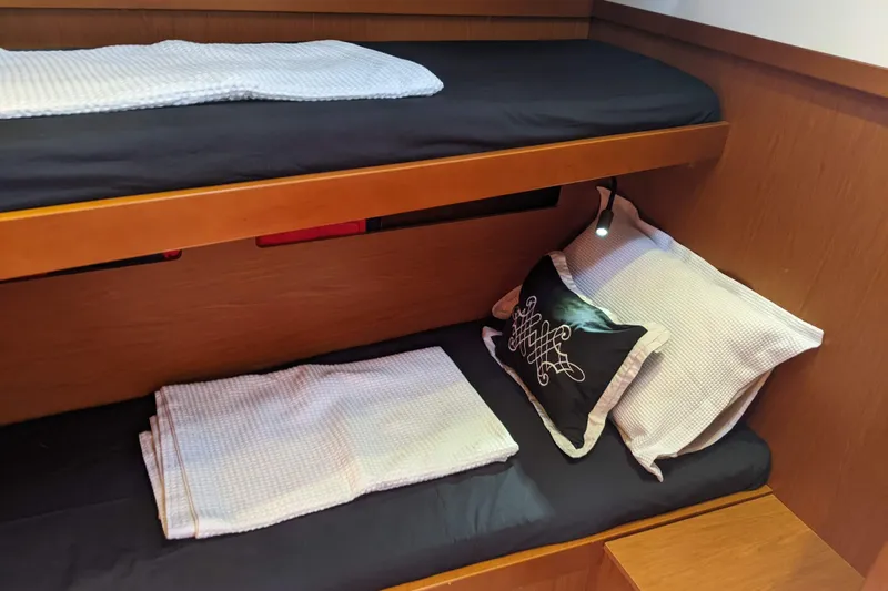 Boxter Yacht Photos Pics Cozy bunk beds in 2013 Beneteau Sense 50 yacht cabin, featuring elegant bedding and reading light.