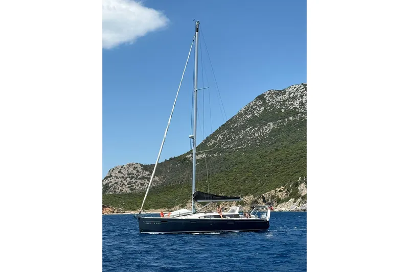Boxter Yacht Photos Pics 2013 Beneteau Sense 50 sailboat on blue water with scenic mountain backdrop.