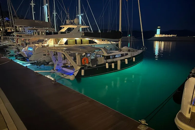 Boxter Yacht Photos Pics 2013 Beneteau Sense 50 yacht docked at night, illuminated by underwater lights.