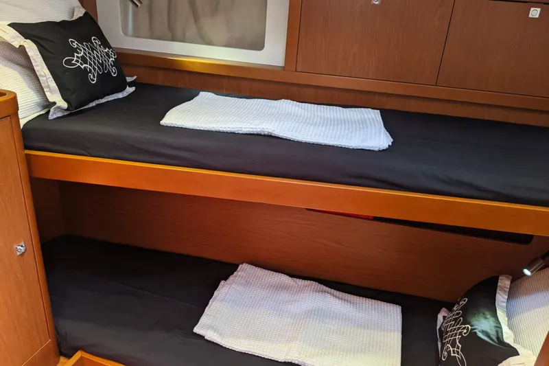 Boxter Yacht Photos Pics Interior of 2013 Beneteau Sense 50 yacht with wooden bunk beds and elegant bedding.