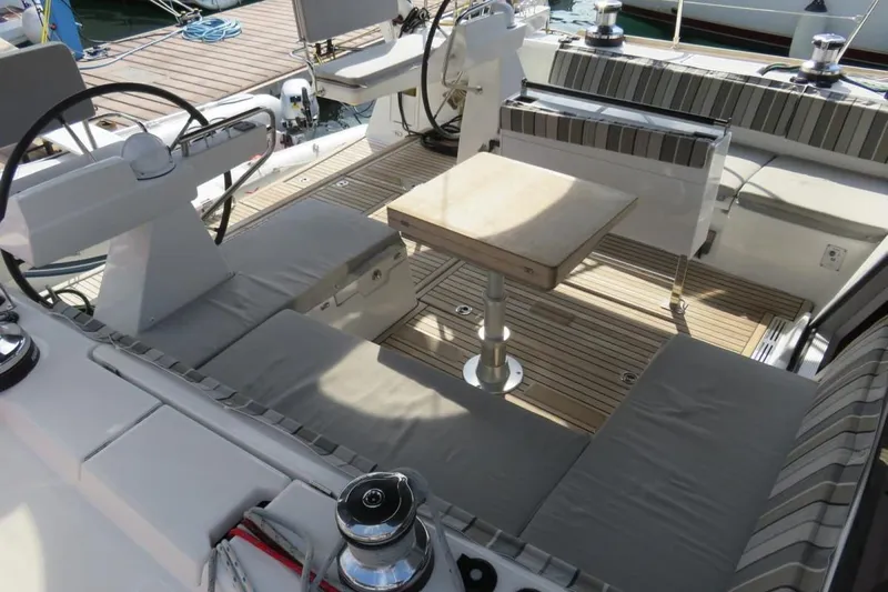Boxter Yacht Photos Pics 2013 Beneteau Sense 50 yacht cockpit with cushioned seating and wooden table.