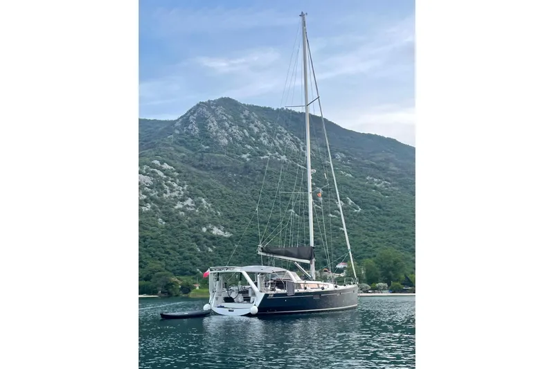 Boxter Yacht Photos Pics 2013 Beneteau Sense 50 sailboat anchored with scenic mountain backdrop.