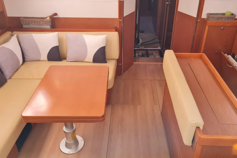 Boxter Yacht Photos Pics Interior of 2013 Beneteau Sense 50 yacht with cozy seating and wooden table.