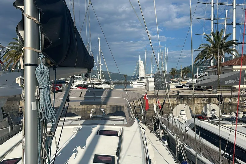 Boxter Yacht Photos Pics 2013 Beneteau Sense 50 yacht docked in a marina, surrounded by other sailboats and palm trees.