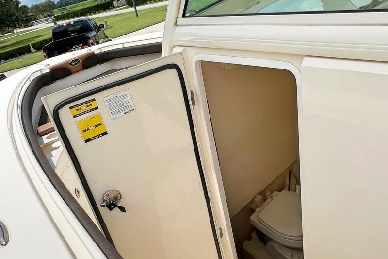  Yacht Photos Pics 2014 Scout 275 LXF boat interior with open cabin door revealing toilet.