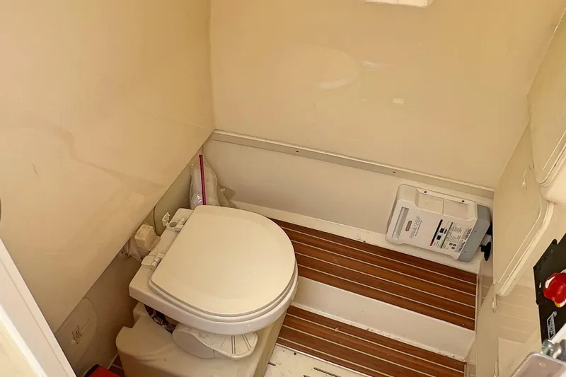  Yacht Photos Pics 2014 Scout 275 LXF boat bathroom with wooden flooring and compact toilet.