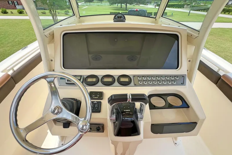  Yacht Photos Pics 2014 Scout 275 LXF boat dashboard with steering wheel and control panel.