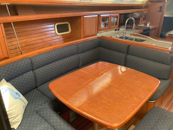Fela Yacht Photos Pics Luxurious interior of 2009 Hunter 49 Aft Cockpit yacht with wood table and cushioned seating.