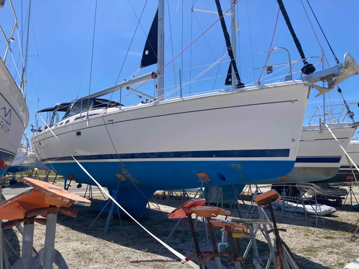 Fela Yacht Photos Pics 2009 Hunter 49 Aft Cockpit sailboat on dry dock, white hull with blue stripe.