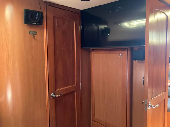 Fela Yacht Photos Pics Interior of 2009 Hunter 49 Aft Cockpit yacht with wooden cabinetry and mounted TV.