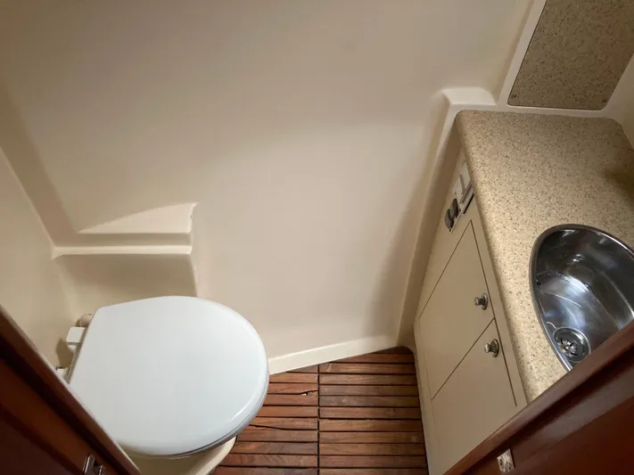 Fela Yacht Photos Pics 2009 Hunter 49 Aft Cockpit bathroom with wooden floor, toilet, and sink.