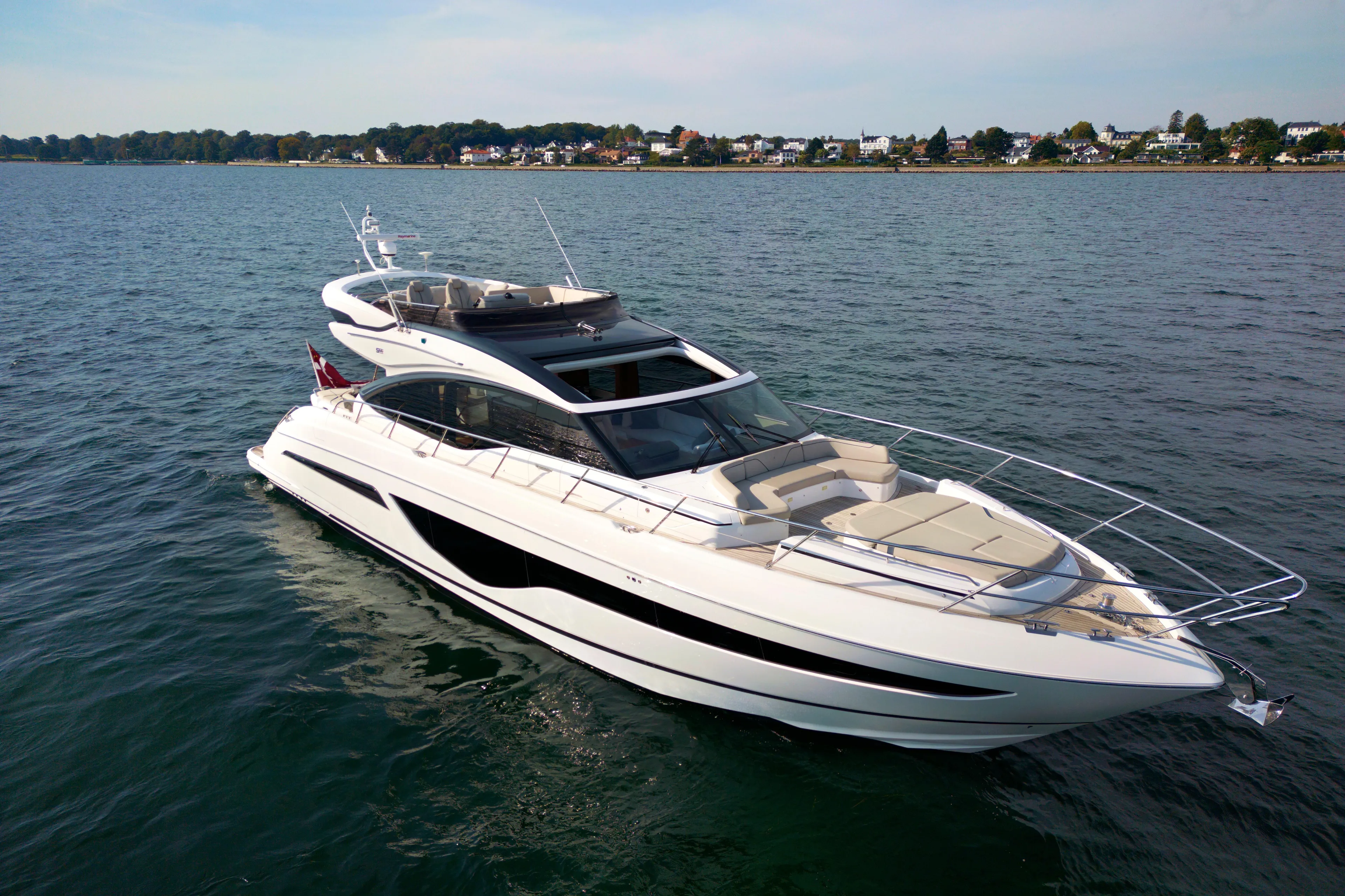  Yacht Photos Pics Luxurious 2021 Princess S66 yacht cruising on calm waters near a scenic coastline.