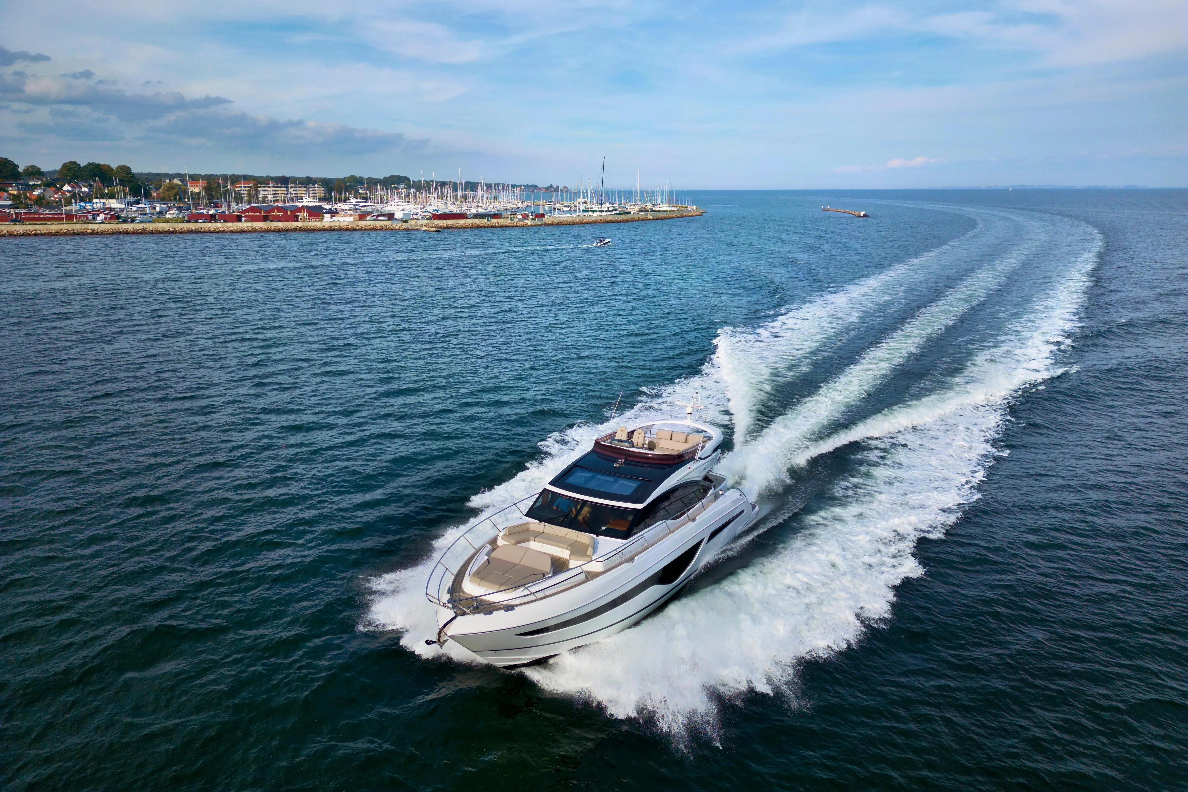  Yacht Photos Pics Luxurious 2021 Princess S66 yacht cruising on open water near a marina.