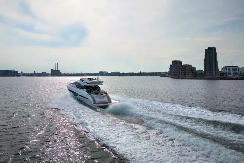  Yacht Photos Pics Luxury yacht Princess S66 cruising on open water, 2021 model, with city skyline in background.