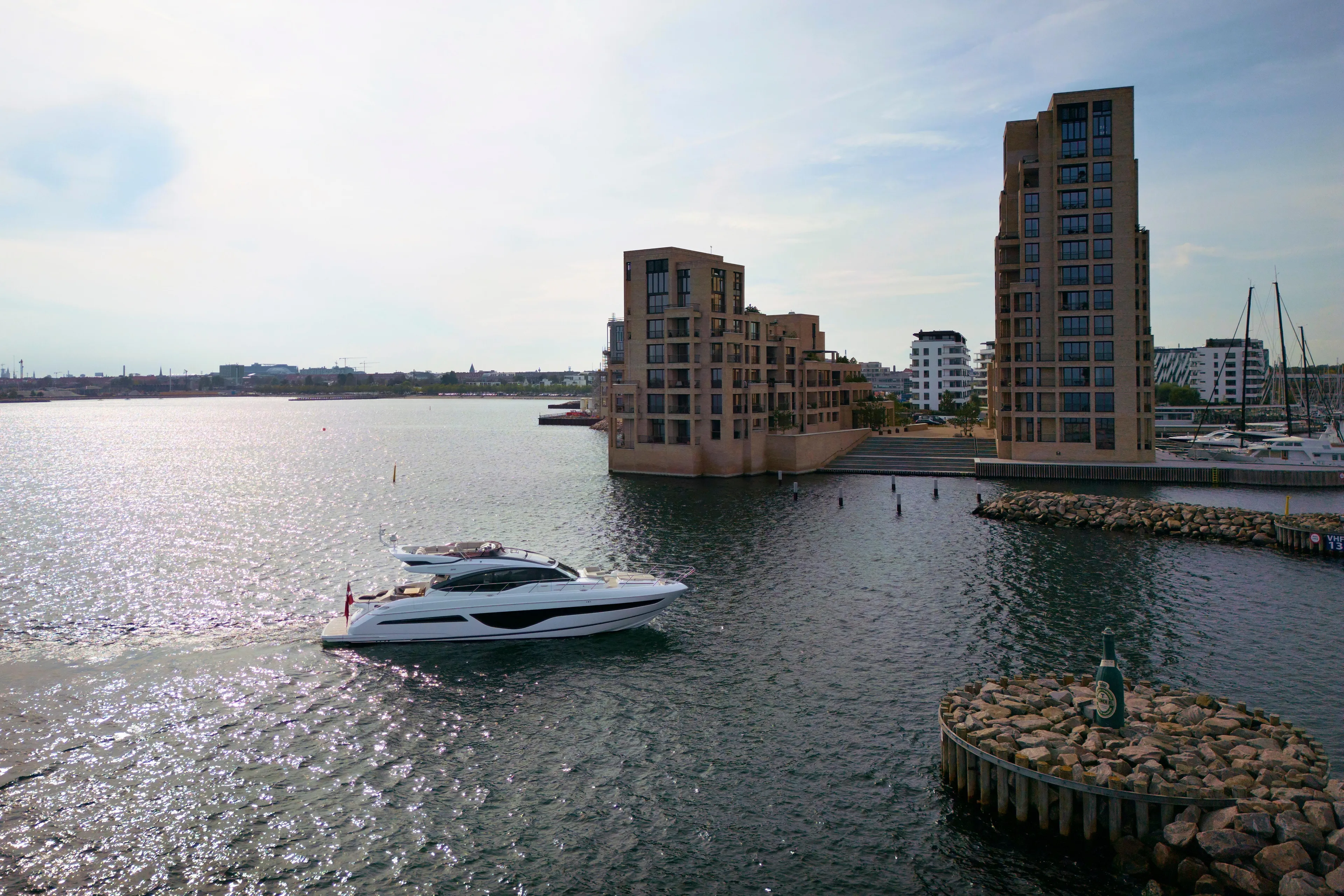  Yacht Photos Pics 2021 Princess S66 yacht cruising near modern waterfront buildings.