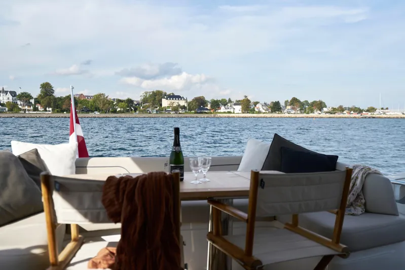  Yacht Photos Pics Luxury yacht Princess S66 deck with seating, table, and scenic waterfront view.