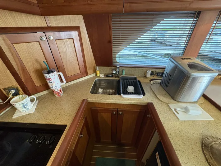 Rabbit Hole Yacht Photos Pics 2005 Luhrs 41 Convertible kitchen with wooden cabinets, sink, and countertop appliances.