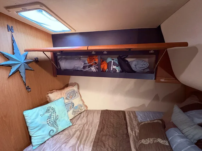 Rabbit Hole Yacht Photos Pics 2005 Luhrs 41 Convertible cabin with storage, decorative pillows, and nautical wall decor.