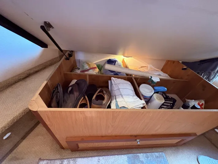 Rabbit Hole Yacht Photos Pics Under-seat storage on 2005 Luhrs 41 Convertible boat, containing shoes and miscellaneous items.