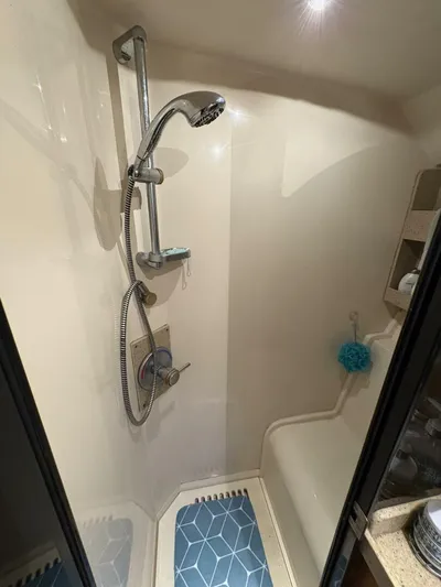 Rabbit Hole Yacht Photos Pics Shower area in 2005 Luhrs 41 Convertible boat with modern fixtures and blue mat.
