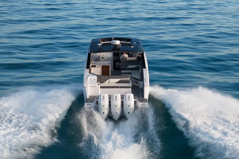  Yacht Photos Pics 2026 Cruisers Yachts 38 GLS OB speeding on open water, rear view.