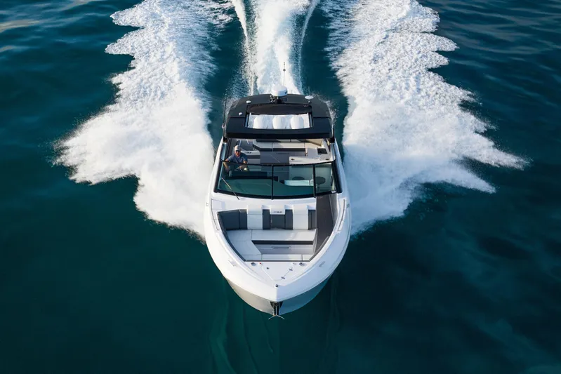  Yacht Photos Pics 2026 Cruisers Yachts 38 GLS OB speeding on open water, aerial view.
