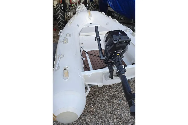  Yacht Photos Pics Inflatable boat with outboard motor, parked on gravel, near a Sea Ray 425 Sundancer (2005).