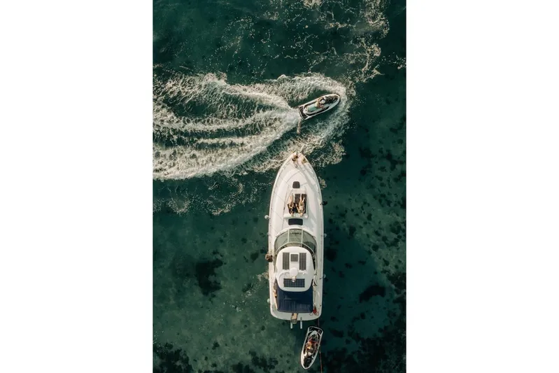  Yacht Photos Pics Aerial view of 2005 Searay Sundancer 390 yacht with jet ski on clear water.