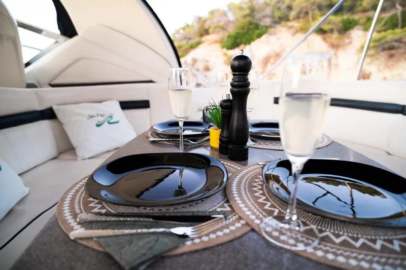  Yacht Photos Pics Elegant dining setup on 2005 Searay Sundancer 390 yacht with champagne and black plates.