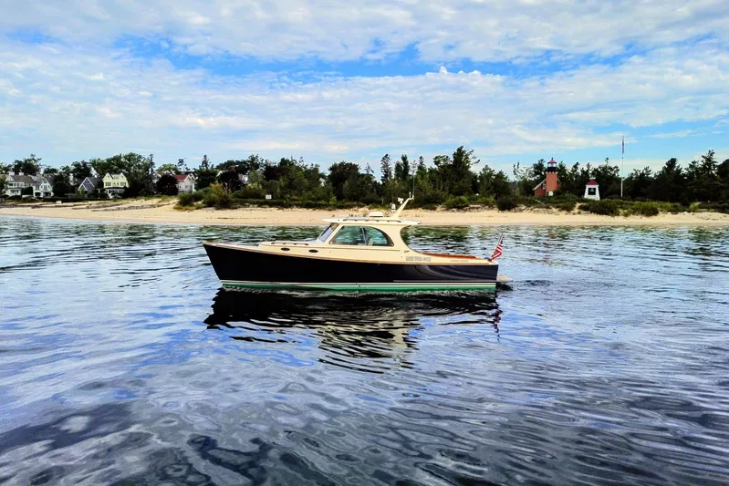 Annie Beau Yacht Photos Pics 2011 Hinckley Picnic Boat 37 MKIII cruising near a scenic shoreline.