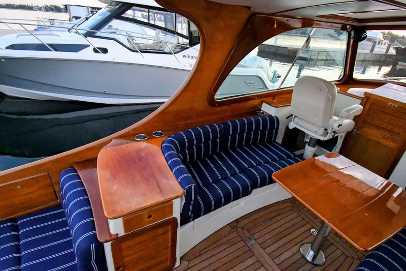 Annie Beau Yacht Photos Pics Interior of 2011 Hinckley Picnic Boat 37 MKIII with elegant wood finish and striped seating.