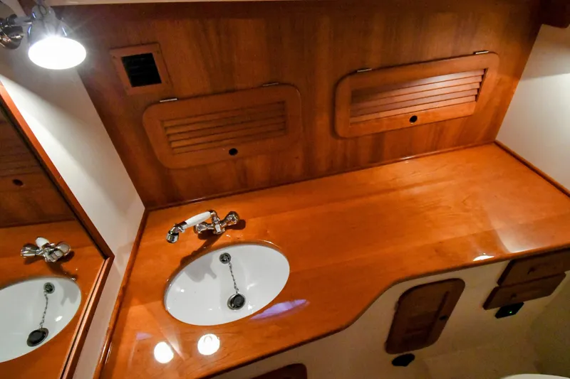 Annie Beau Yacht Photos Pics Luxurious wooden interior of 2011 Hinckley Picnic Boat 37 MKIII with sink and storage.
