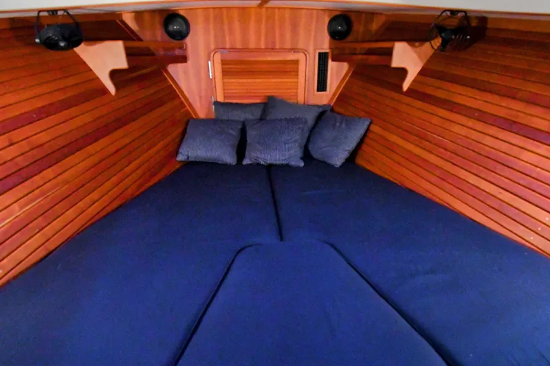 Annie Beau Yacht Photos Pics Interior cabin of 2011 Hinckley Picnic Boat 37 MKIII with blue cushions and wooden paneling.