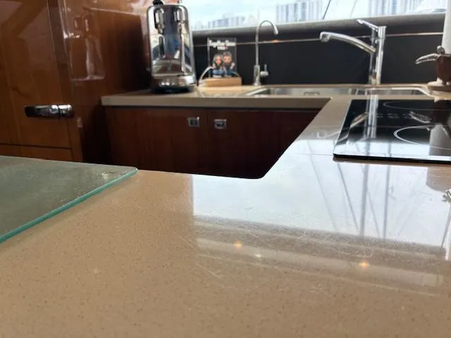 Mv Dream Yacht Photos Pics Modern kitchen interior on a 2012 Viking Princess Fly yacht, featuring sleek countertops and appliances.