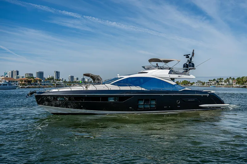  Yacht Photos Pics 2019 Azimut S7 yacht cruising on a sunny day with city skyline in background.
