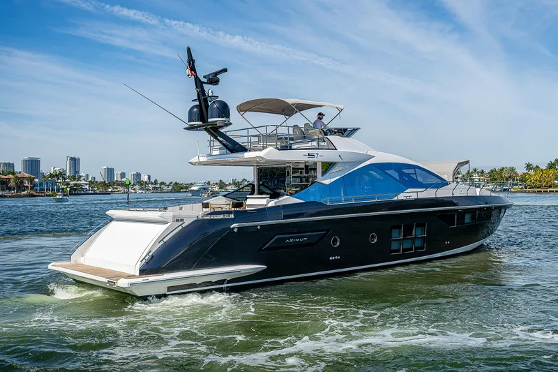  Yacht Photos Pics 2019 Azimut S7 yacht cruising on a sunny day, with city skyline in the background.