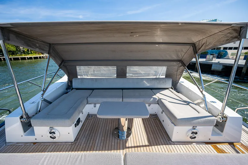 Yacht Photos Pics 2019 Azimut S7 yacht deck with shaded seating and table, docked by the water.