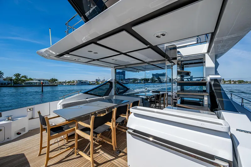  Yacht Photos Pics 2019 Azimut S7 yacht deck with dining area, overlooking serene waters and modern architecture.