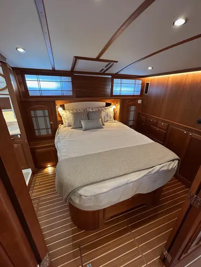 Fil The Tide Yacht Photos Pics 2021 Sabre 48 Salon Express bedroom with elegant wood paneling and cozy bedding.