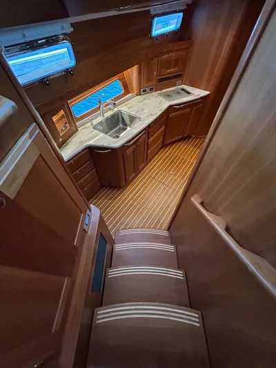 Fil The Tide Yacht Photos Pics 2021 Sabre 48 Salon Express interior with wooden cabinetry and modern kitchen design.