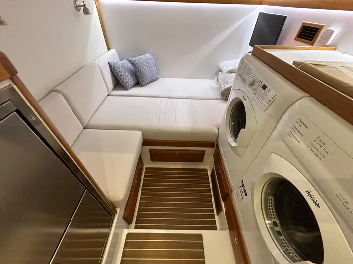Fil The Tide Yacht Photos Pics 2021 Sabre 48 Salon Express interior with laundry area and cozy seating.