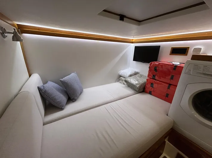 Fil The Tide Yacht Photos Pics 2021 Sabre 48 Salon Express interior with sofa, pillows, TV, and washing machine.