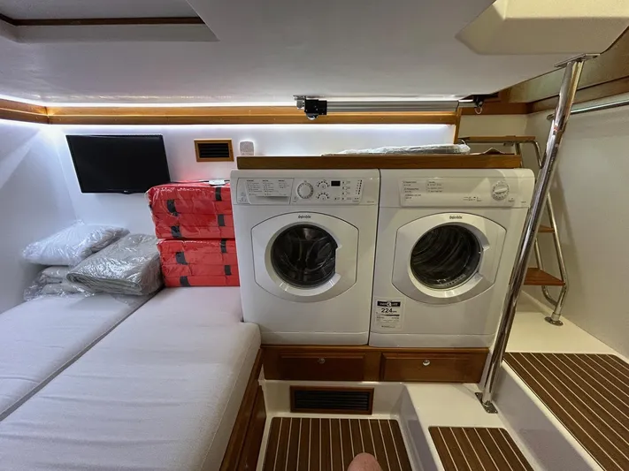 Fil The Tide Yacht Photos Pics Laundry area in 2021 Sabre 48 Salon Express yacht with washer, dryer, and seating.