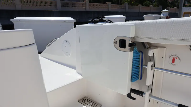  Yacht Photos Pics 2023 Pursuit OS 355 Offshore boat interior with storage compartment and fire extinguisher sign.