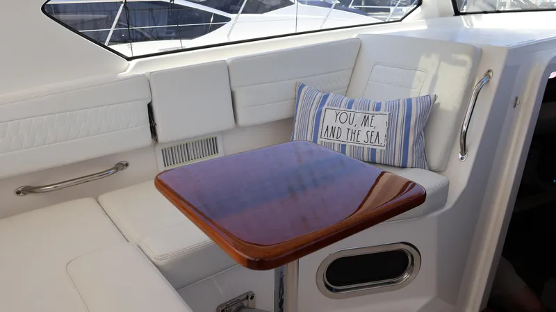  Yacht Photos Pics 2023 Pursuit OS 355 Offshore interior with cushioned seating and decorative pillow.