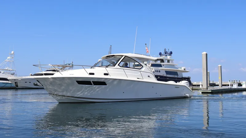 Yacht Photos Pics 2023 Pursuit OS 355 Offshore yacht docked in a marina under clear blue skies.