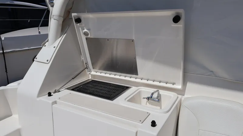  Yacht Photos Pics 2023 Pursuit OS 355 Offshore boat kitchenette with sink and grill.
