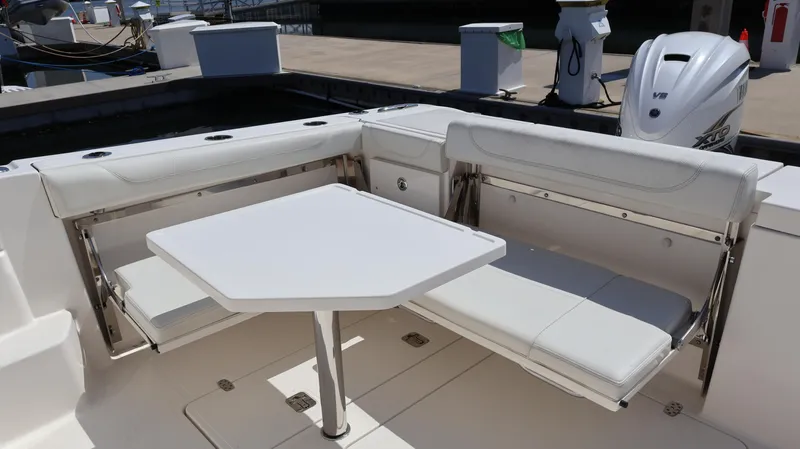  Yacht Photos Pics 2023 Pursuit OS 355 Offshore boat with white seating and table in the cockpit area.