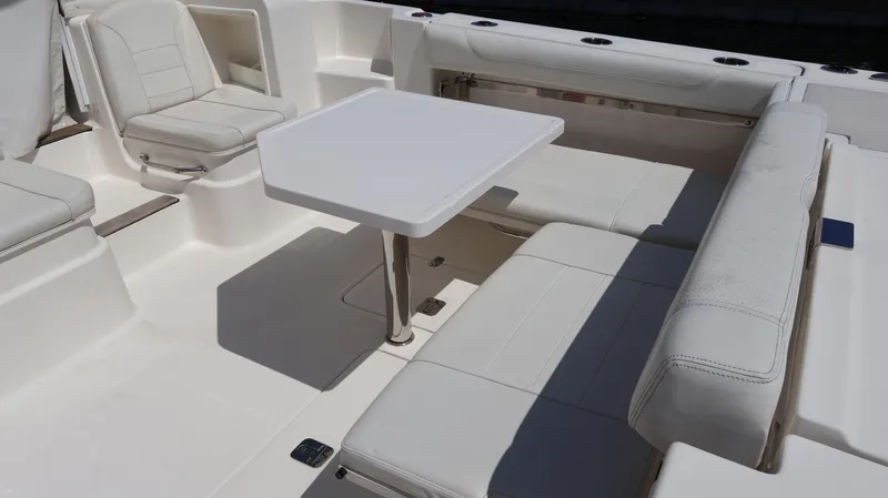  Yacht Photos Pics 2023 Pursuit OS 355 Offshore boat interior with white seating and table.