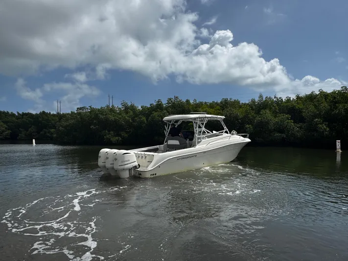  Yacht Photos Pics 2005 Hydra-Sports 3300 VX boat cruising on a calm waterway under a cloudy sky.